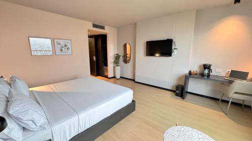 a bedroom with a bed and a desk with a laptop at Tequendama Hotel Medellín - Estadio in Medellín