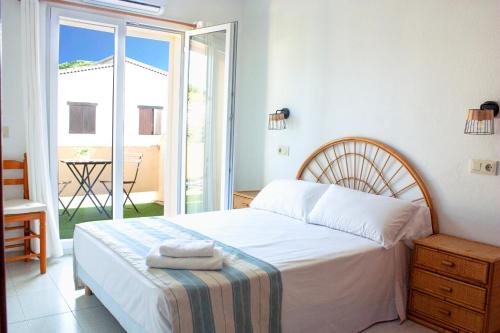a bedroom with a bed and a balcony with a table at Ca L'Anxoveta - casa amb piscina a prop de la platja a l'escala in L'Escala