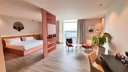 a hotel room with a bed and a desk at Tequendama Hotel Medellín - Estadio in Medellín