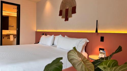 a bedroom with a large bed with white pillows at Tequendama Hotel Medellín - Estadio in Medellín