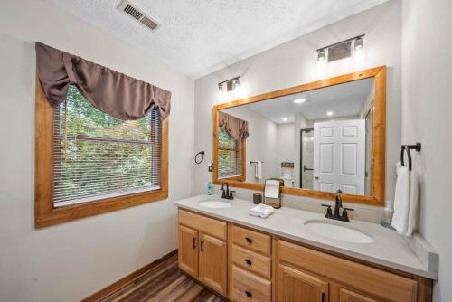 Un baño con lavabo y un espejo grande. en The Smore the Bearier, en Zionville