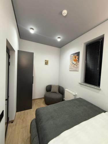 a bedroom with a bed and a chair at BOND HOUSE Dilijan in Dilijan