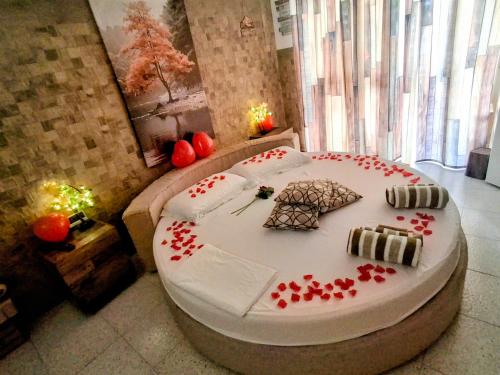a room with a large white bed with red hearts on it at "Il Quercione" Room With SpA in Lama Di Peligni