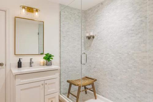 Un baño con ducha con lavabo y taburete. en Modern 2BR Apartment in Vibrant Chinatown, en Vancouver
