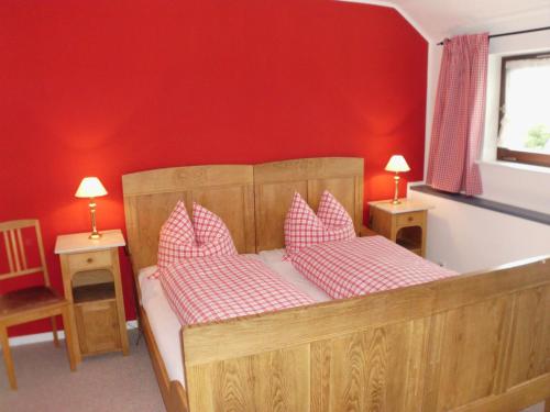 a bedroom with a wooden bed with red walls at Ferienhaus Suedhang in Winterberg