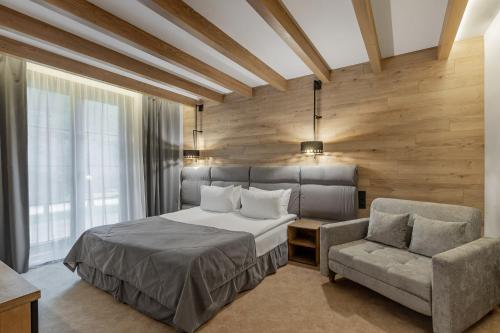 a bedroom with a bed and a chair at Bukovel Hotel in Bukovel