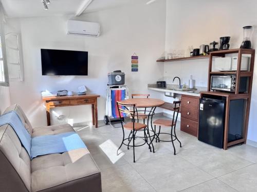 a living room with a table and a kitchen at Bella Buzios Apartamentos in Búzios