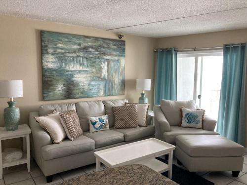 a living room with a couch and a table at Emerald Skye 36 in Orange Beach