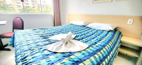 a hotel room with a bed with towels on it at Hotel Kolman in Capão da Canoa