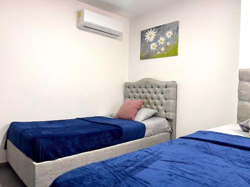 La ElviraにあるApartamento Norte Valledupar cerca Río Guatapuríのベッドルーム1室(青いシーツが備わるベッド2台付)
