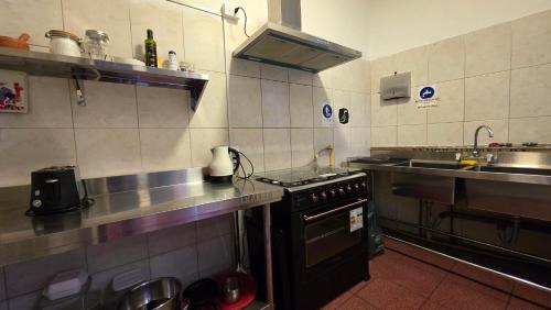 a kitchen with a stove and a sink at Oceana Suites Chile Hostel in Santiago