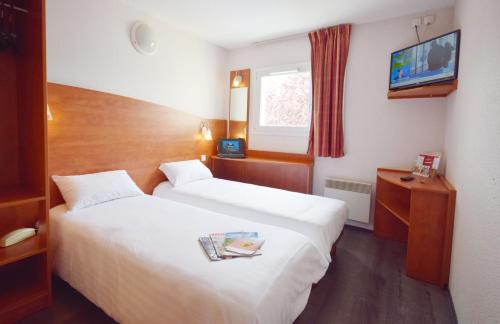 a hotel room with two beds and a tv at Brit Hotel Reims La Pompelle in Reims