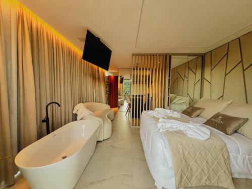 a hotel room with a bath tub and a bed at Studios Heaven in Gramado