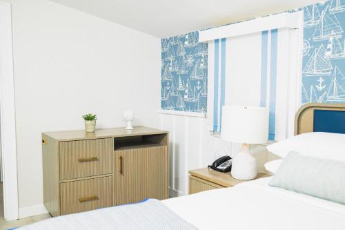 a bedroom with two beds and a dresser with a lamp at Danfords Hotel & Marina in Port Jefferson Station