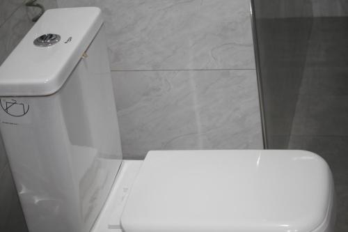 a bathroom with a white toilet and a sink at Serene villas in Kitala