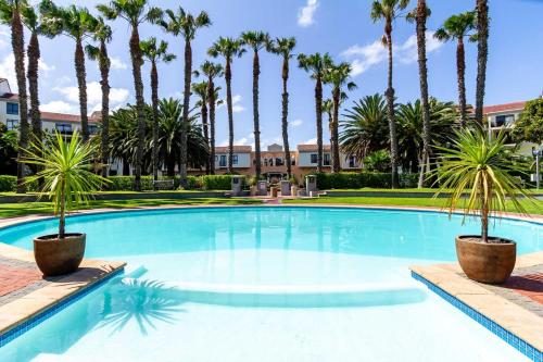 プリングル・ベイにあるLuxurious Palm View Apartment Cape Townのヤシの木が並ぶ大型プール
