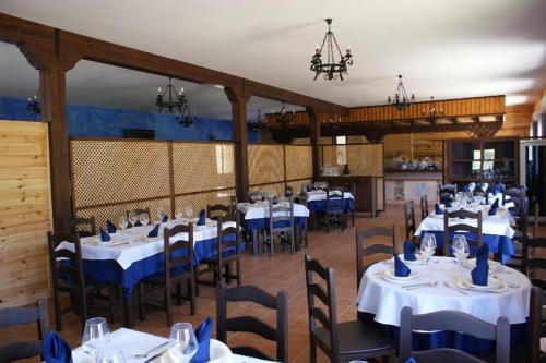 un comedor con mesas y sillas con servilletas azules en Lincetur Cabañeros - Centro de Turismo Rural en Navas de Estena