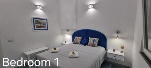a bedroom with a bed with a blue headboard at Cielo e Mare in Positano