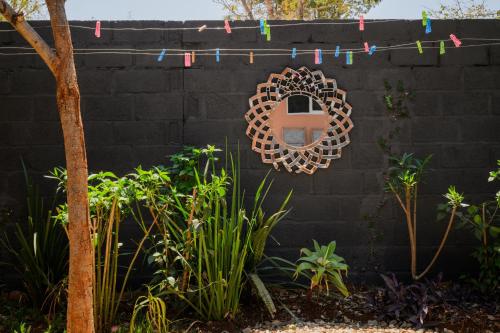 a mirror hanging on a wall with plants at Villa Stone Apartments in Lusaka