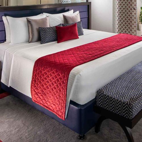 a large bed with red and white blankets and pillows at Hotel Nysha Delhi in New Delhi