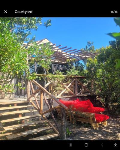 a group of red objects sitting under a wooden structure at DesertDewEstate in Nanyuki