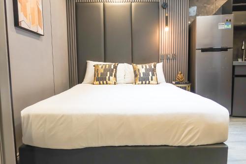 a large bed in a room with a refrigerator at Comfy 2 Bedroom Apartment by ReCharge in Singapore