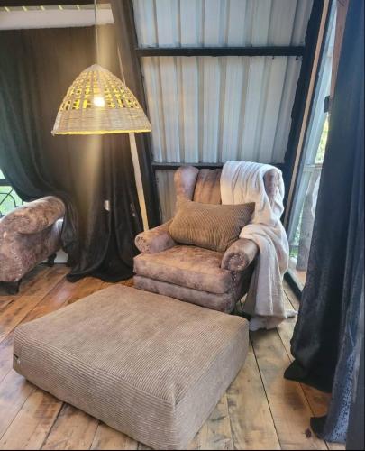 a living room with a chair and a ottoman at DesertDewEstate in Nanyuki