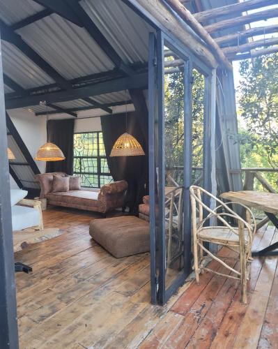 a screened in porch with a couch and a chair at DesertDewEstate in Nanyuki