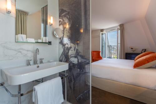 a bathroom with a sink and a bed in a room at Hôtel La Comtesse in Paris