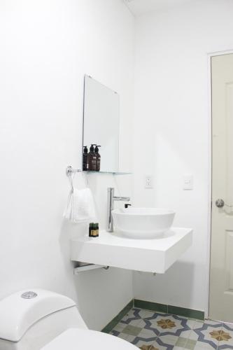 a white bathroom with a sink and a toilet at Hospedaje la gran Tenochtitlán in San Martín Hidalgo