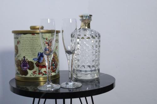 Una botella de vidrio y dos vasos sobre una mesa. en CASA VACANZE VIA CASALE, en Nardò