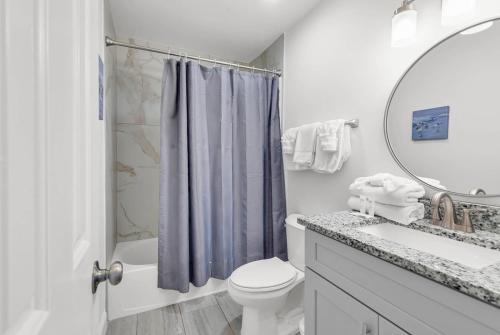 Un baño con inodoro, lavabo y espejo. en SHV B1: The Sweetbay, en Myrtle Beach