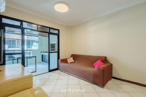 a living room with a couch and a table at Apto c varanda e churrasq em cond beira mar UAR301 in Itapema