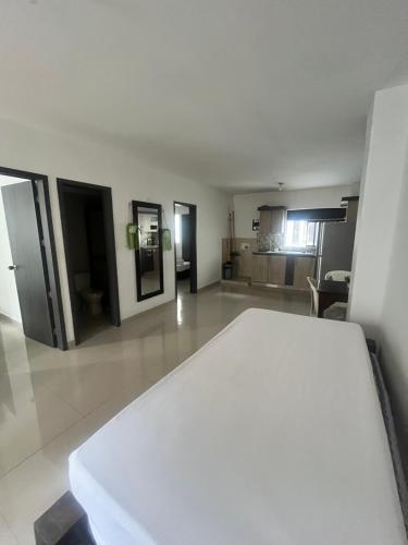 a white table in a room with a kitchen at APARTAMENTO CÉNTRICO con PISCINA a UNA CUADRA in Santa Fe de Antioquia
