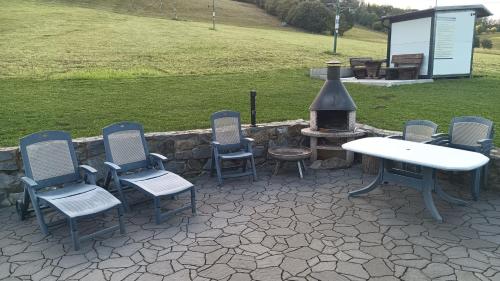 a group of chairs and a table and a fire pit at Sjezdovka Bušín in Busin