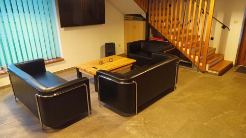 a living room with two chairs and a table at Sjezdovka Bušín in Busin