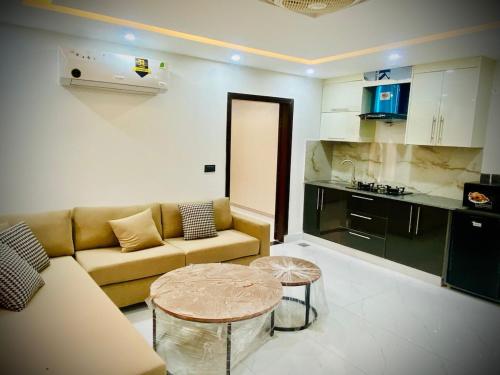 a living room with a couch and a table at Eiffel Luxora Lavender one bed in Lahore