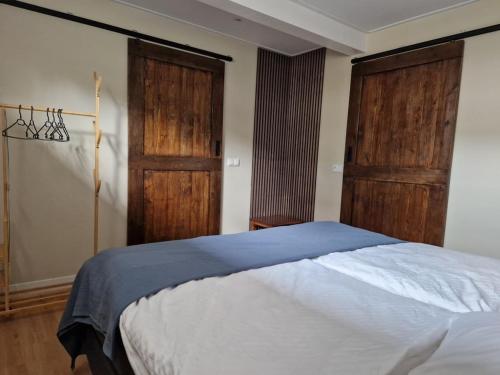 a bedroom with a bed and two wooden doors at Hofstay Twente in Goor