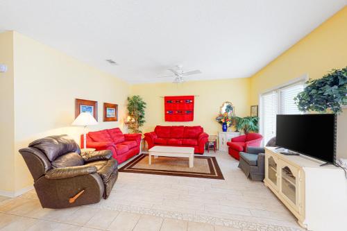a living room with red furniture and a flat screen tv at Charter Landing 1 A9 in Orange Beach