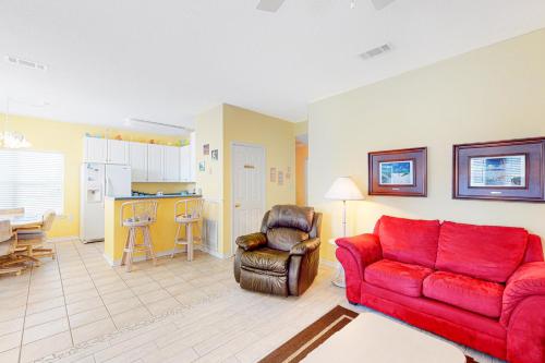 a living room with a red couch and a chair at Charter Landing 1 A9 in Orange Beach
