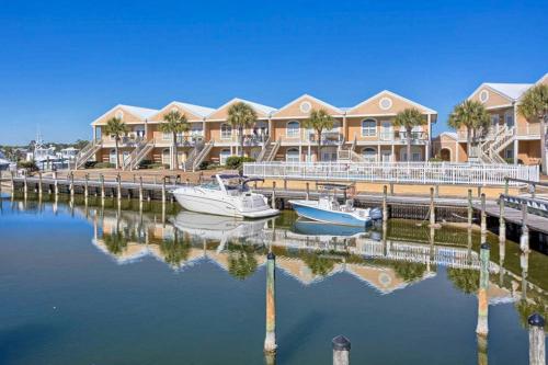 two boats are docked at a marina with houses at Charter Landing 1 A9 in Orange Beach