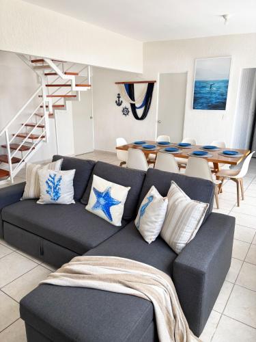 a living room with a couch and a table at Kuxaan Cielo Terraza privada y comodidad a pocos minutos de la playa in Playa del Carmen