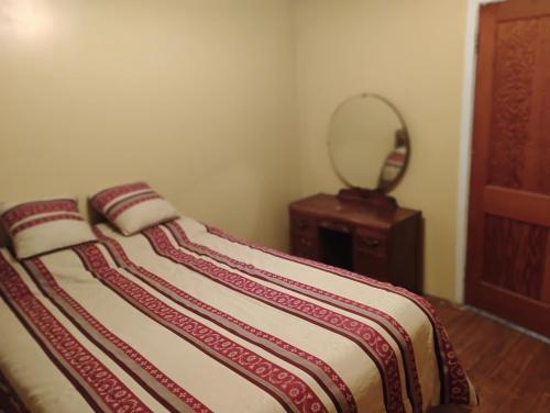 a bed with a striped blanket and a table at 6 Olivia Lane in Deer Lake