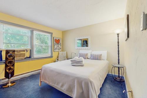 ein Schlafzimmer mit einem weißen Bett und einem Fenster in der Unterkunft The Blue Cottage in Provincetown