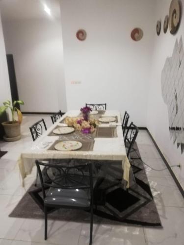 a dining room table with chairs and a white table cloth at Villa Ngaparou Petite-Côte 2 chambres salon in Ngaparou