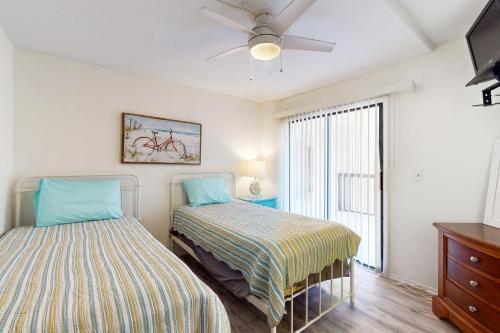 a bedroom with two beds and a window at Santa Maria Condo 102 in Fort Myers Beach