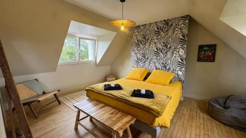 a bedroom with a bed with yellow sheets and a window at Ty Glaz - Maison Bord de mer avec jardin, proche plage in Roscoff