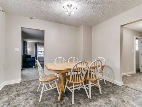a dining room with a wooden table and chairs at Cozy House Near Iowa State Fairgrounds! in Des Moines