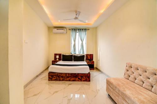 a bedroom with a bed and a couch at Collection O The Hastings Club in Kolkata