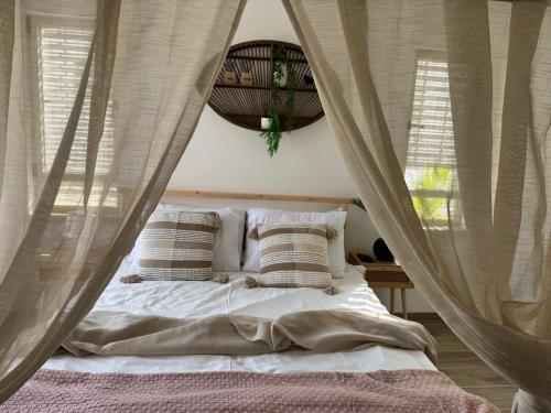 a bedroom with a bed with mosquito nets at אלמה בוטיק - וילה מהממת עם בריכה פרטית in Shlomi